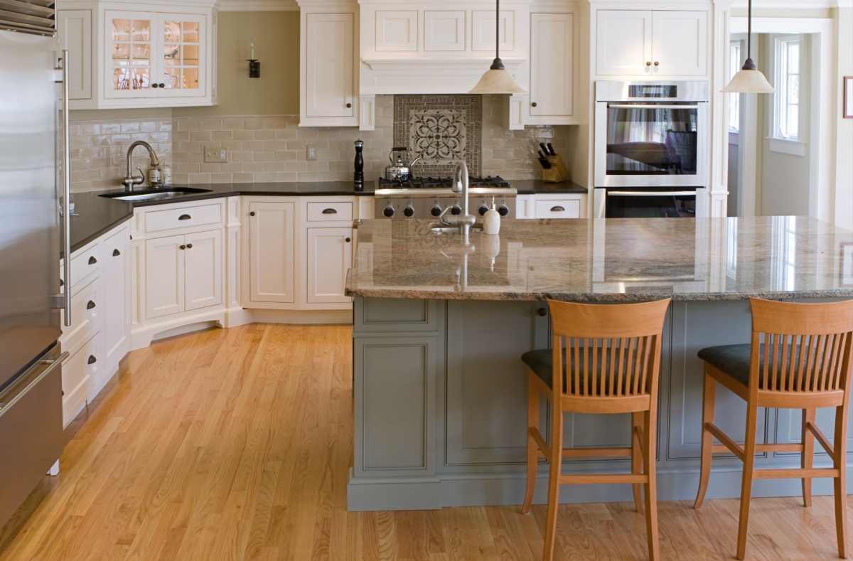 A remodeled kitchen with a blue island and white cabinets